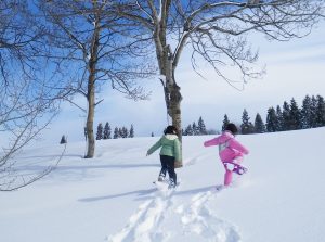 スノーシューを履いて新雪の上を歩く子供